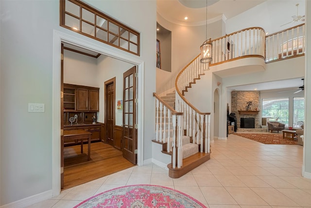 12214 Francel Ln, Cypress, TX 77429 - entryway with stairs, light tile patterned floors, french doors, a towering ceiling, and a fireplace