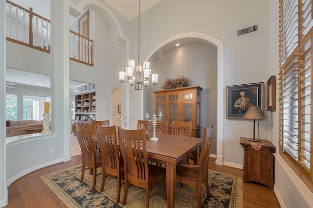 12214 Francel Ln, Cypress, TX 77429 - dining room with a towering ceiling, arched walkways, a chandelier, and wood finished floors