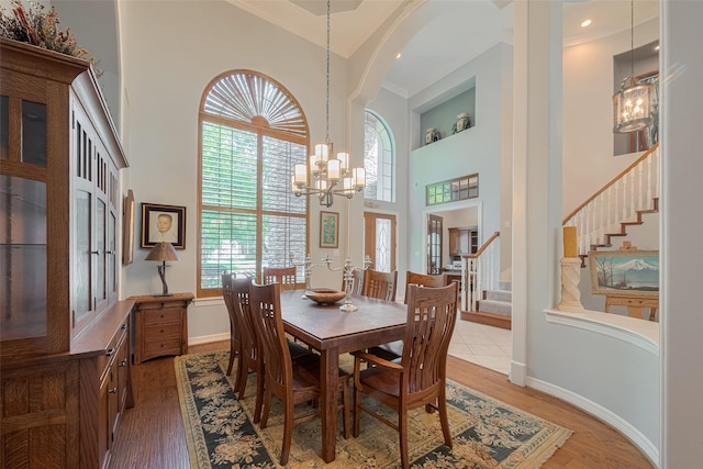 12214 Francel Ln, Cypress, TX 77429 - dining area featuring a chandelier, a towering ceiling, stairs, and wood finished floors