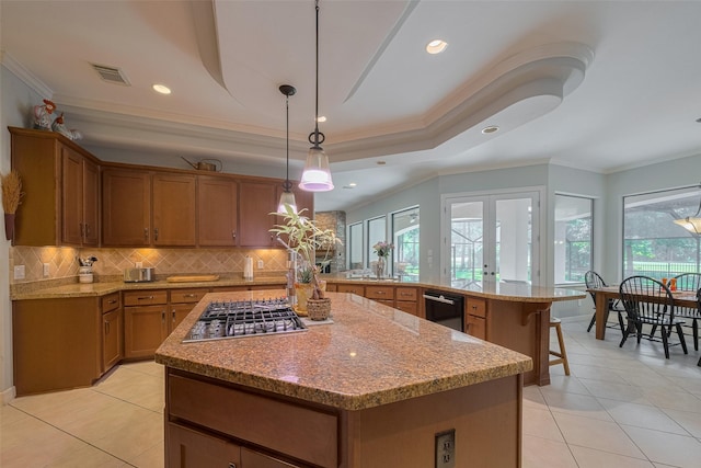 12214 Francel Ln, Cypress, TX 77429 - kitchen with brown cabinets, stainless steel gas stovetop, plenty of natural light, decorative backsplash, and ornamental molding