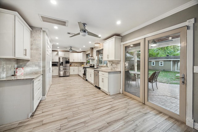 1510 Apple Park Dr, Katy, TX 77450 - kitchen featuring stainless steel appliances, a ceiling fan, wall chimney exhaust hood, backsplash, and recessed lighting