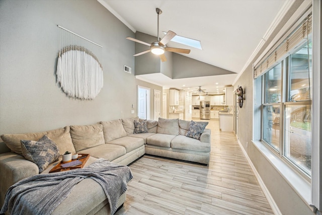 1510 Apple Park Dr, Katy, TX 77450 - living room featuring lofted ceiling, a ceiling fan, crown molding, a skylight, and baseboards