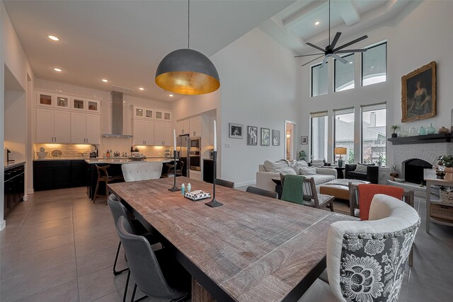 29118 Sage Trace Ct, Fulshear, TX 77441 - dining area featuring ceiling fan, a towering ceiling, tile patterned flooring, recessed lighting, and a fireplace with raised hearth