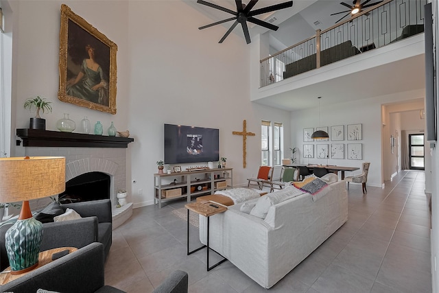 29118 Sage Trace Ct, Fulshear, TX 77441 - tiled living area with a ceiling fan, a high ceiling, a fireplace, and baseboards