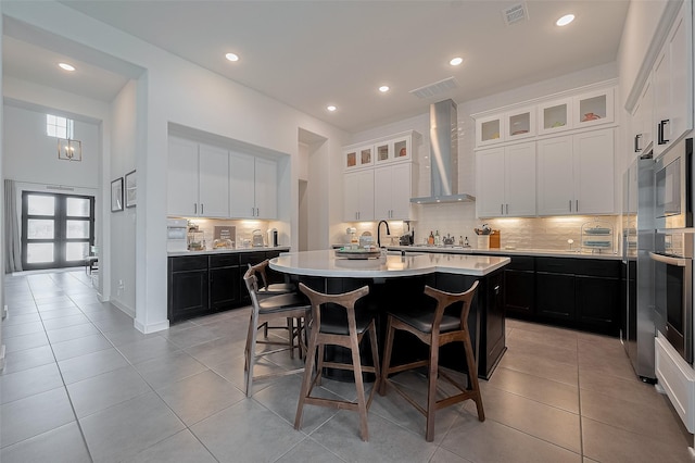 29118 Sage Trace Ct, Fulshear, TX 77441 - kitchen featuring wall chimney range hood, oven, a center island with sink, light tile patterned floors, and recessed lighting