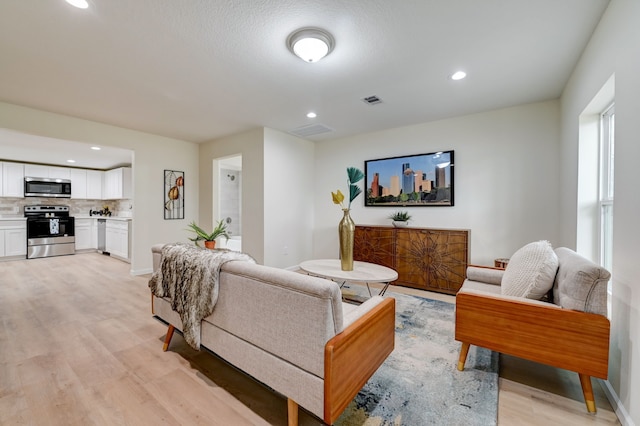 104 18th Ave N, Texas City, TX 77590 - living room featuring light wood-style flooring, recessed lighting, and baseboards