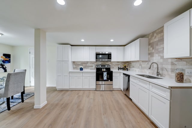 104 18th Ave N, Texas City, TX 77590 - kitchen featuring stainless steel appliances, a sink, decorative backsplash, light countertops, and white cabinets