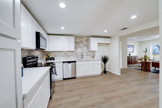 104 18th Ave N, Texas City, TX 77590 - kitchen featuring stainless steel appliances, a sink, backsplash, white cabinets, and light countertops