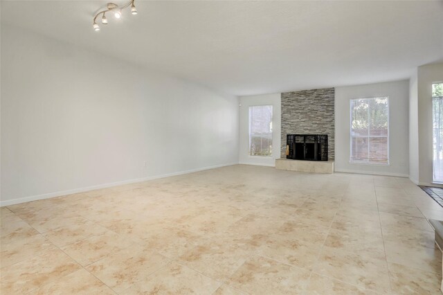 8718 Maplecrest Dr, Houston, TX 77099 - unfurnished living room with a stone fireplace, healthy amount of natural light, and tile patterned floors