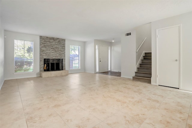 8718 Maplecrest Dr, Houston, TX 77099 - unfurnished living room with stairs, a tiled fireplace, baseboards, and tile patterned floors