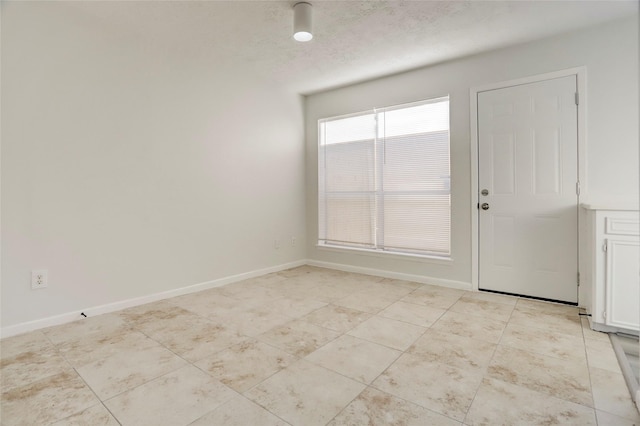 8718 Maplecrest Dr, Houston, TX 77099 - unfurnished dining area with light tile patterned floors, baseboards, and a textured ceiling