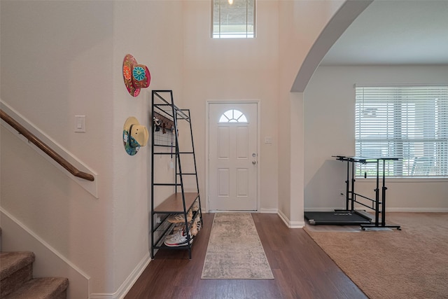 308 Morning Dove Trl, Sealy, TX 77474 - foyer entrance with arched walkways, baseboards, dark wood-style flooring, and stairway