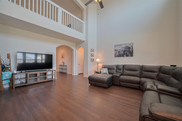 308 Morning Dove Trl, Sealy, TX 77474 - living area with arched walkways, a ceiling fan, wood finished floors, baseboards, and a towering ceiling