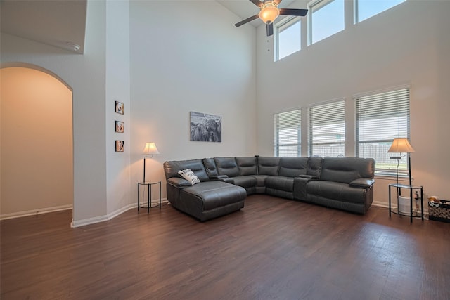 308 Morning Dove Trl, Sealy, TX 77474 - living area with arched walkways, a towering ceiling, ceiling fan, dark wood-type flooring, and baseboards
