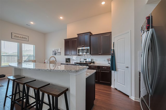 308 Morning Dove Trl, Sealy, TX 77474 - kitchen with stainless steel appliances, dark wood-style floors, a breakfast bar, tasteful backsplash, and recessed lighting