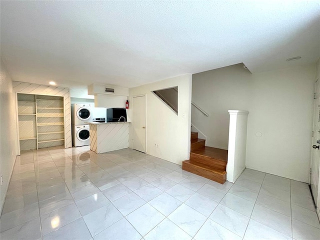 2100 Wilcrest Dr Unit 123, Houston, TX 77042 - unfurnished living room featuring stacked washing machine and dryer and stairway