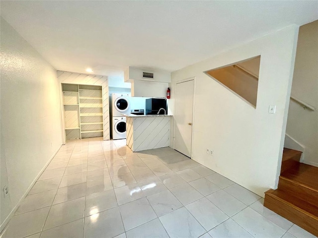 2100 Wilcrest Dr Unit 123, Houston, TX 77042 - unfurnished living room featuring stacked washer / dryer, stairs, light tile patterned flooring, and recessed lighting