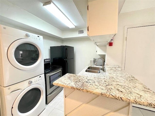 2100 Wilcrest Dr Unit 123, Houston, TX 77042 - washroom featuring stacked washer / drying machine and light tile patterned flooring