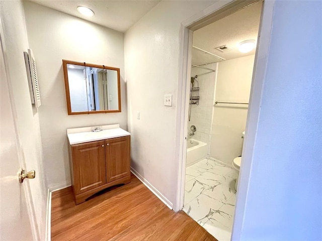 2100 Wilcrest Dr Unit 123, Houston, TX 77042 - bathroom featuring baseboards, vanity, toilet, bathtub / shower combination, and marble finish flooring