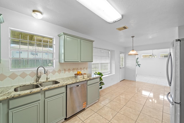 13911 Fraser Lake Ln, Houston, TX 77083 - kitchen with green cabinets, stainless steel appliances, a sink, plenty of natural light, and a textured ceiling