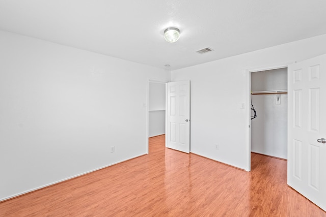 13911 Fraser Lake Ln, Houston, TX 77083 - unfurnished bedroom featuring light wood-type flooring, a spacious closet, a closet, and baseboards