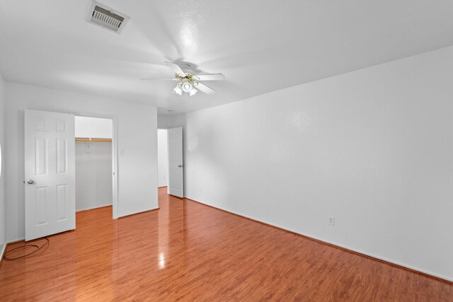 13911 Fraser Lake Ln, Houston, TX 77083 - unfurnished bedroom with a closet, light wood-style flooring, a ceiling fan, and a spacious closet