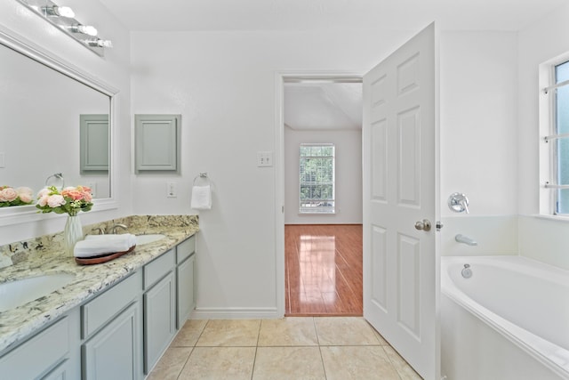 13911 Fraser Lake Ln, Houston, TX 77083 - bathroom with double vanity, a garden tub, baseboards, and tile patterned floors