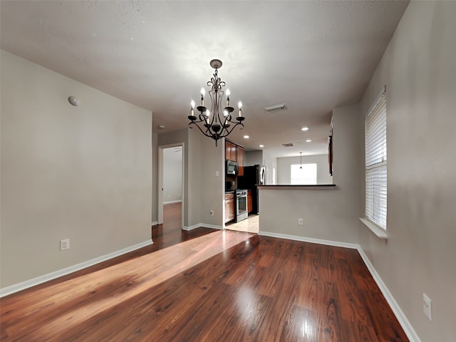10807 Tobar Falls Cir, Houston, TX 77064 - unfurnished living room featuring a chandelier, wood finished floors, and baseboards