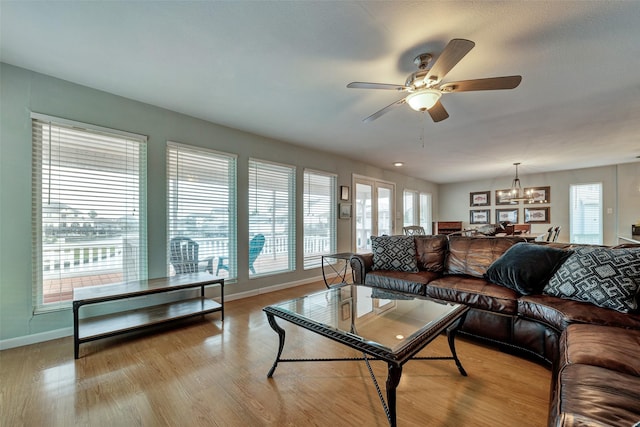 1327 Tiki Dr, Tiki Island, TX 77554 - living area featuring a chandelier, baseboards, ceiling fan, and wood finished floors