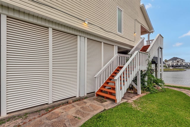1327 Tiki Dr, Tiki Island, TX 77554 - view of exterior entry with a water view and a lawn