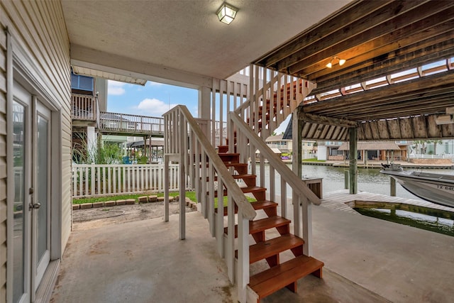 1327 Tiki Dr, Tiki Island, TX 77554 - view of patio with stairs, a water view, and a dock