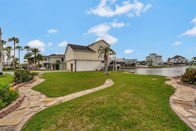 1327 Tiki Dr, Tiki Island, TX 77554 - view of green lawn with a water view, stairway, and a residential view