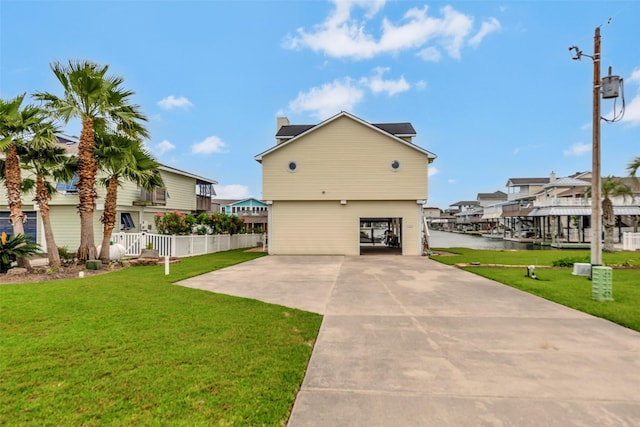1327 Tiki Dr, Tiki Island, TX 77554 - view of home's exterior with a chimney, a yard, a water view, driveway, and a residential view