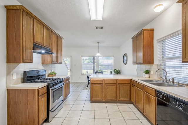 3102 Spring Flower Ln, Spring, TX 77388 - kitchen with gas stove, dishwasher, under cabinet range hood, a sink, and brown cabinetry