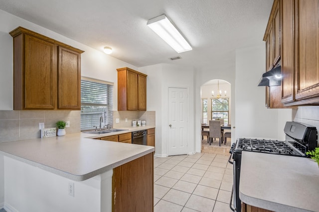 3102 Spring Flower Ln, Spring, TX 77388 - kitchen featuring a sink, arched walkways, gas stove, dishwasher, and brown cabinets