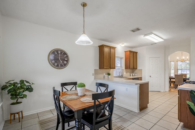 3102 Spring Flower Ln, Spring, TX 77388 - dining area featuring arched walkways, light tile patterned floors, a chandelier, and baseboards