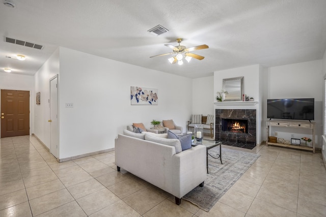 3102 Spring Flower Ln, Spring, TX 77388 - living room featuring light tile patterned floors, a tiled fireplace, a ceiling fan, and baseboards
