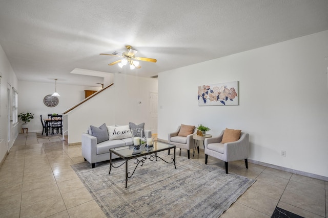 3102 Spring Flower Ln, Spring, TX 77388 - living room with light tile patterned floors, stairway, ceiling fan, a textured ceiling, and baseboards