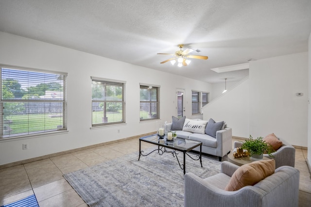 3102 Spring Flower Ln, Spring, TX 77388 - tiled living room with plenty of natural light, ceiling fan, baseboards, and a textured ceiling
