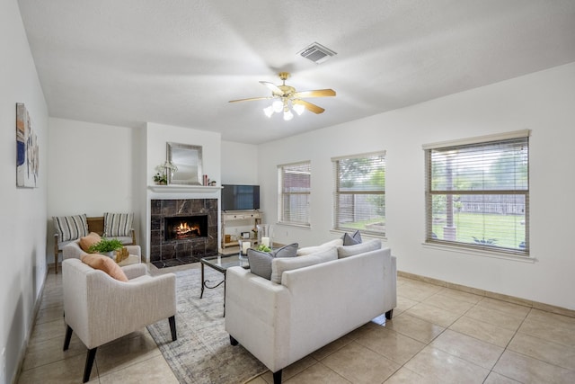 3102 Spring Flower Ln, Spring, TX 77388 - living area with a tiled fireplace, ceiling fan, light tile patterned floors, and baseboards