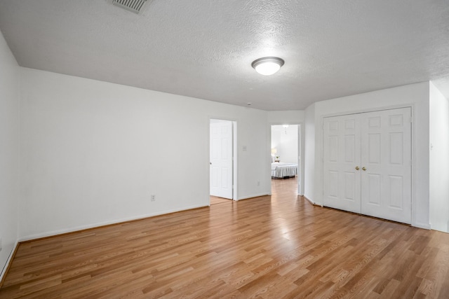 3102 Spring Flower Ln, Spring, TX 77388 - unfurnished bedroom with light wood finished floors, a textured ceiling, a closet, and baseboards