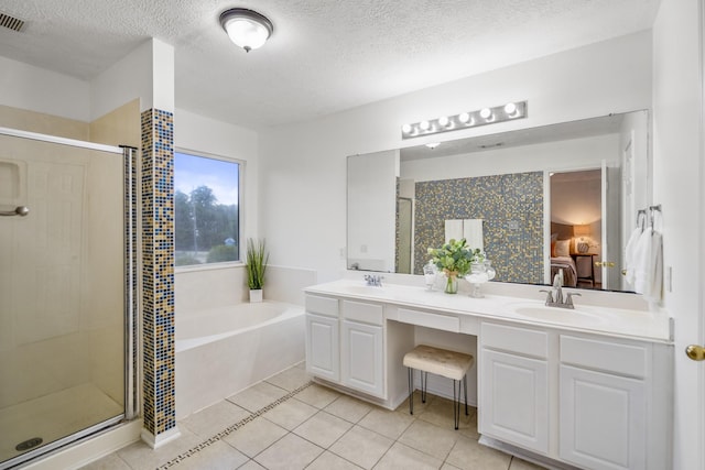 3102 Spring Flower Ln, Spring, TX 77388 - full bathroom with a stall shower, a garden tub, double vanity, a textured ceiling, and tile patterned flooring