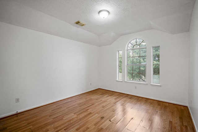 3102 Spring Flower Ln, Spring, TX 77388 - spare room featuring wood finished floors, lofted ceiling, baseboards, and a textured ceiling