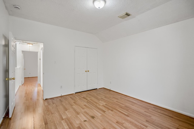 3102 Spring Flower Ln, Spring, TX 77388 - unfurnished bedroom featuring light wood-type flooring, lofted ceiling, baseboards, a textured ceiling, and a closet