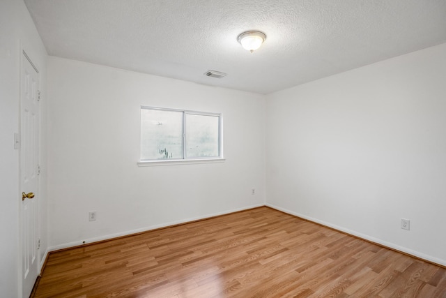 3102 Spring Flower Ln, Spring, TX 77388 - empty room with wood finished floors, a textured ceiling, and baseboards