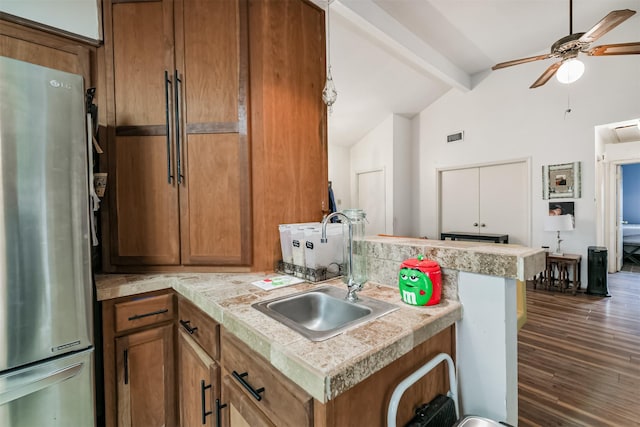 12206 Tawakom Dr, Tomball, TX 77375 - kitchen with freestanding refrigerator, a sink, beam ceiling, brown cabinetry, and high vaulted ceiling