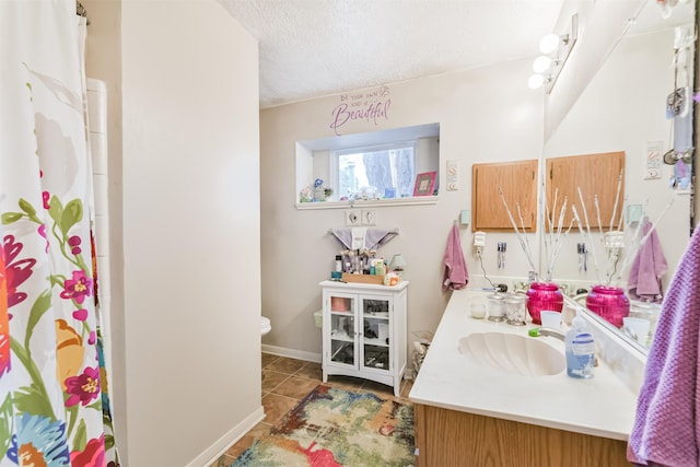 12206 Tawakom Dr, Tomball, TX 77375 - bathroom with double vanity, tile patterned floors, toilet, a textured ceiling, and a shower with curtain