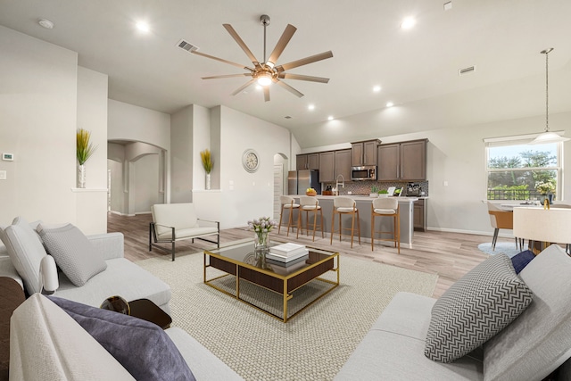 24743 Levante Dr, Richmond, TX 77406 - living room featuring arched walkways, light wood-type flooring, ceiling fan, vaulted ceiling, and recessed lighting