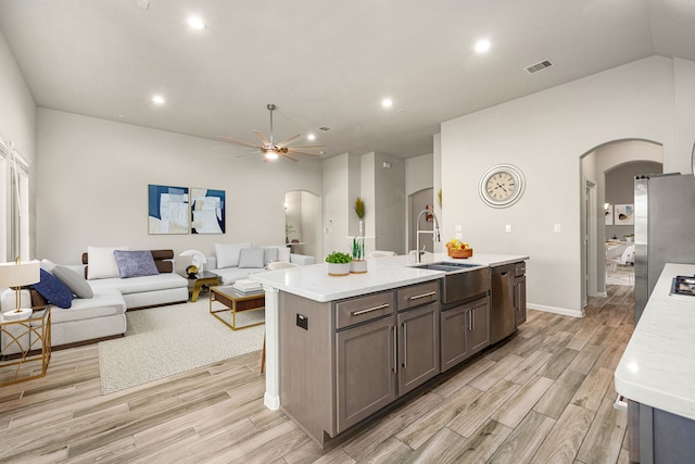 24743 Levante Dr, Richmond, TX 77406 - kitchen with arched walkways, a sink, light wood finished floors, and recessed lighting