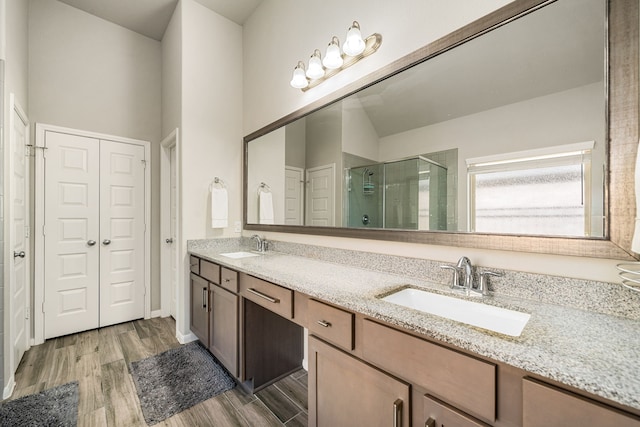24743 Levante Dr, Richmond, TX 77406 - bathroom featuring a stall shower, wood finished floors, and double vanity